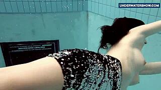 Bruneta bljeska sjajne sise pod vodom na javnom bazenu za uzbuđenje