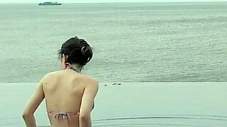 skinny student with cute legs relaxes by the infinity pool