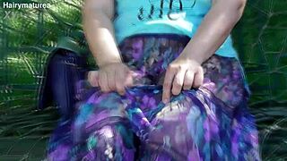 This chubby mature woman walks outdoors in a see-through dress flashing her hairy pussy under the skirt.