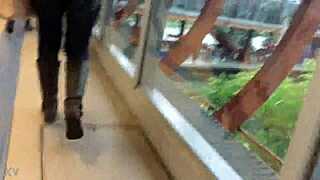 In the crowded train setting, a woman sports a casual jacket and sturdy boots during her daily commute. Part 1.