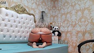 blonde latina milf dances sensually in white lingerie with black accents. her big tits and ass captivate the scene.