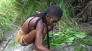 hot african native woman cooks in jungle kitchen with nature around her skinny frame