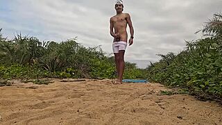 African dude jerks off and cums on beach