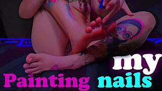curly croatian brunette paints sexy tattooed toes with tongue out