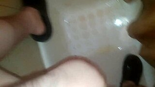 A guy jerks off while peeing and shoots his jizz everywhere.