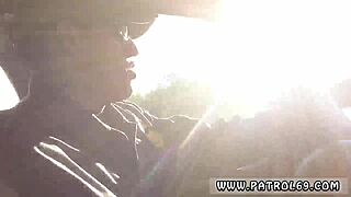 Dominant cop pulls over brunette in police uniform for outdoor action.