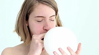 watch this young babe blow and pop her first balloon while giving a blowjob