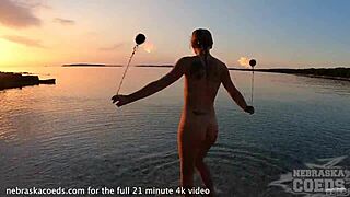 nude fire dancing on beach at sunset