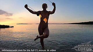 nude fire dancing on beach at sunset